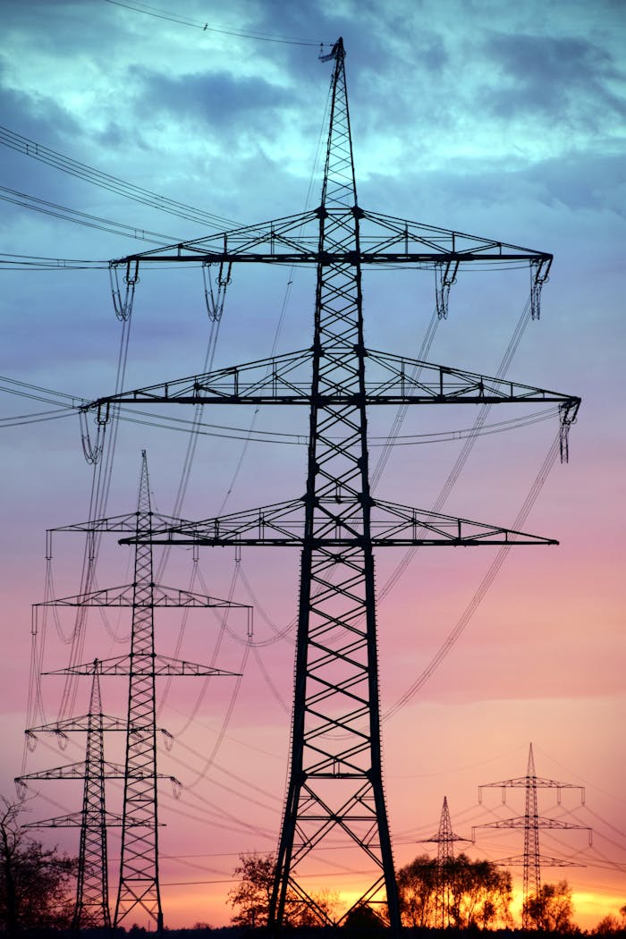 Mastering the First Impression: Your intriguing post title goes here Electricity pylons silhouetted against a dramatic sunset sky, showcasing high voltage transmission.